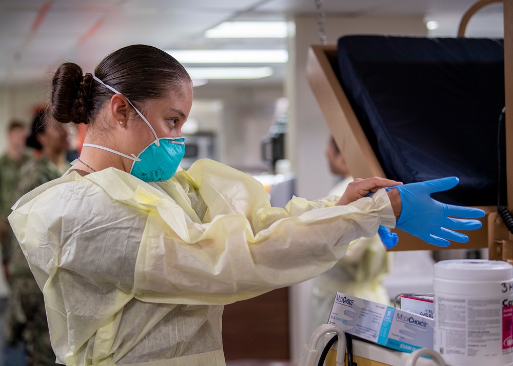 USNS Mercy Sailor Dons Surgical Gloves