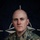 NATO BG-P EIB and ESB awardees A U.S. Army soldier named Cerney poses for an official portrait against a NATO flag backdrop. The image is part of a NATO Enhanced Forward Presence (eFP) Battle Group promotional campaign. The soldier wears MultiCam (OCP) camouflage uniform with visible unit patches and name tape.