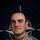 NATO BG-P EIB and ESB awardees A U.S. Army soldier poses for an official portrait in front of a NATO flag backdrop. The soldier is wearing MultiCam (OCP) camouflage uniform with visible name tape reading 'ESFAHAN' and a U.S. Army tape. The image is part of a NATO eFP (enhanced Forward Presence) Battle Group Poland promotional campaign.