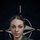 NATO BG-P EIB and ESB awardees A female military personnel member poses in front of a NATO flag for an official promotional portrait. She is wearing Croatian Armed Forces digital camouflage uniform with visible unit and national insignia. The image is part of a NATO Enhanced Forward Presence (eFP) Battle Group public affairs campaign.