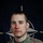 NATO BG-P EIB and ESB awardees A U.S. Army soldier poses for an official portrait in front of a NATO flag backdrop. The soldier is wearing MultiCam (OCP) camouflage uniform with visible military badges and insignia. The image is associated with NATO's enhanced Forward Presence (eFP) Battle Group Poland.