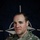 NATO BG-P Soldiers test on EIB and ESB tasks A U.S. Army soldier named Spease poses for an official portrait in front of a NATO flag backdrop. The image is part of a NATO Enhanced Forward Presence (eFP) Battle Group Poland social media campaign. The soldier is wearing MultiCam (OCP) camouflage uniform with visible U.S. Army and NATO insignia.