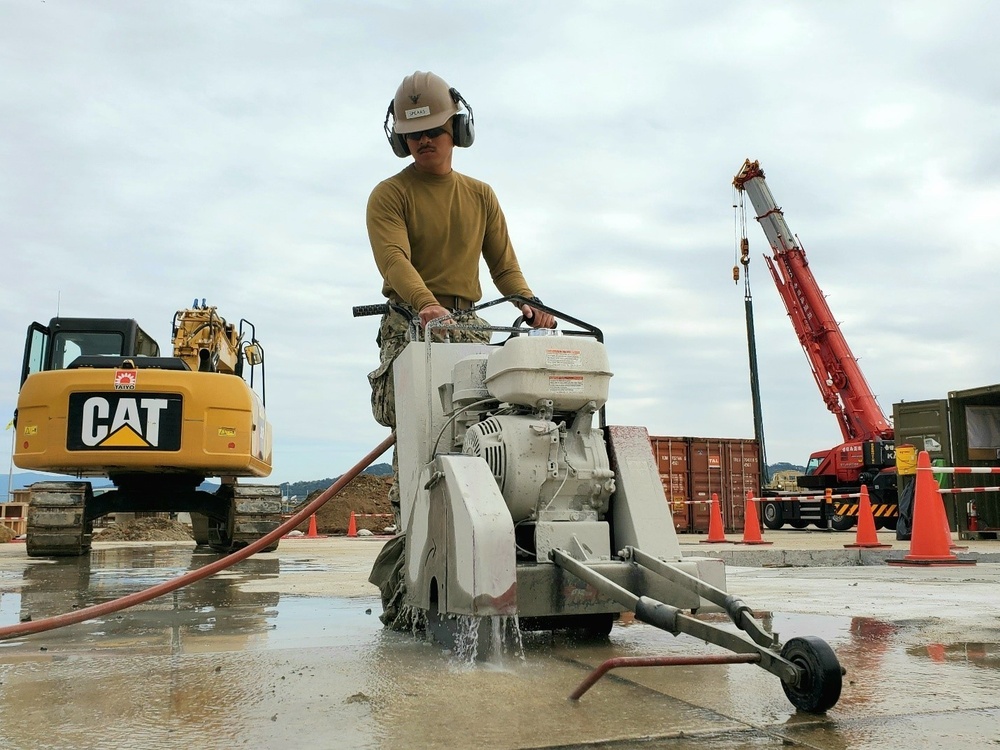 U.S. Navy Seabees with NMCB-5’s Detail Sasebo work on two pre-engineered buildings for NBU-7