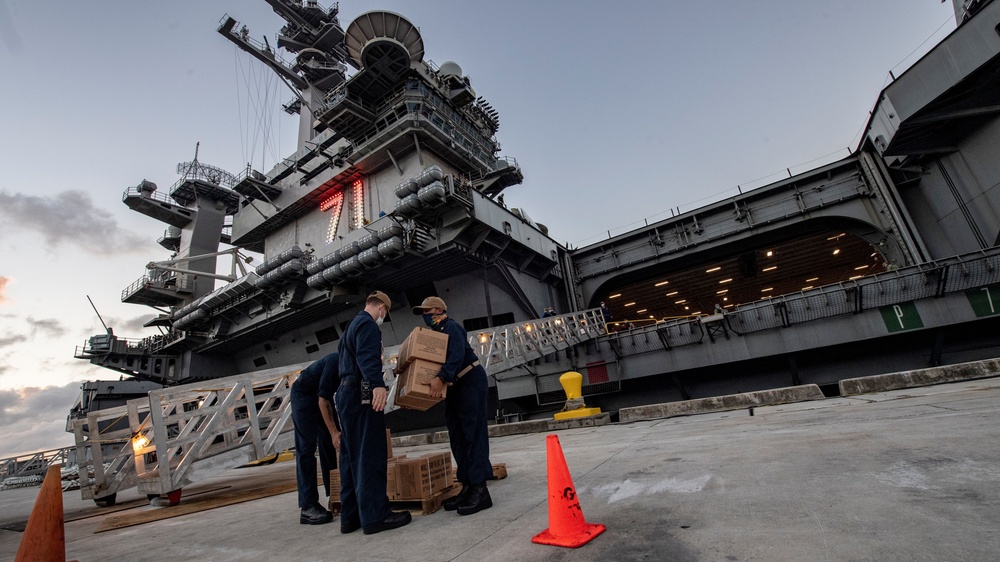 USS Theodore Roosevelt (CVN 71) move meals, ready to eat (MREs) for Sailors