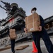 USS Theodore Roosevelt (CVN 71) move meals, ready to eat (MREs) for Sailors