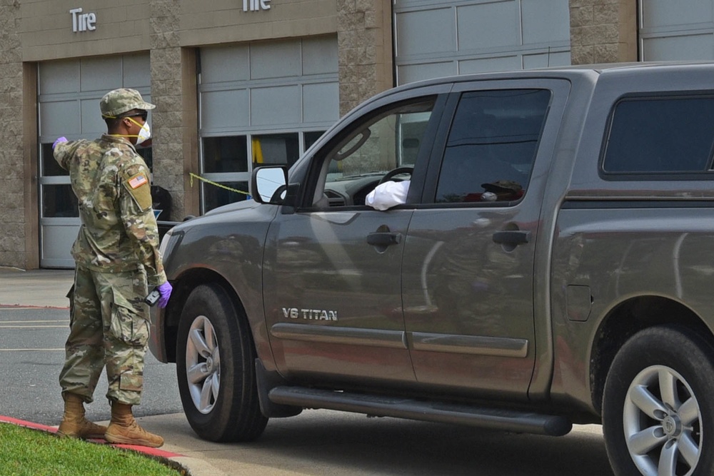 La National Guard assist with traffic control for drive through testing