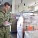 Logistics Specialist 2nd Class Jarred Stone checks cargo inventory