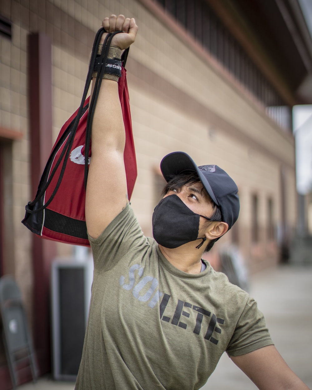 A U.S. Marine lifts a weighted bag during an adaptive physical training event 