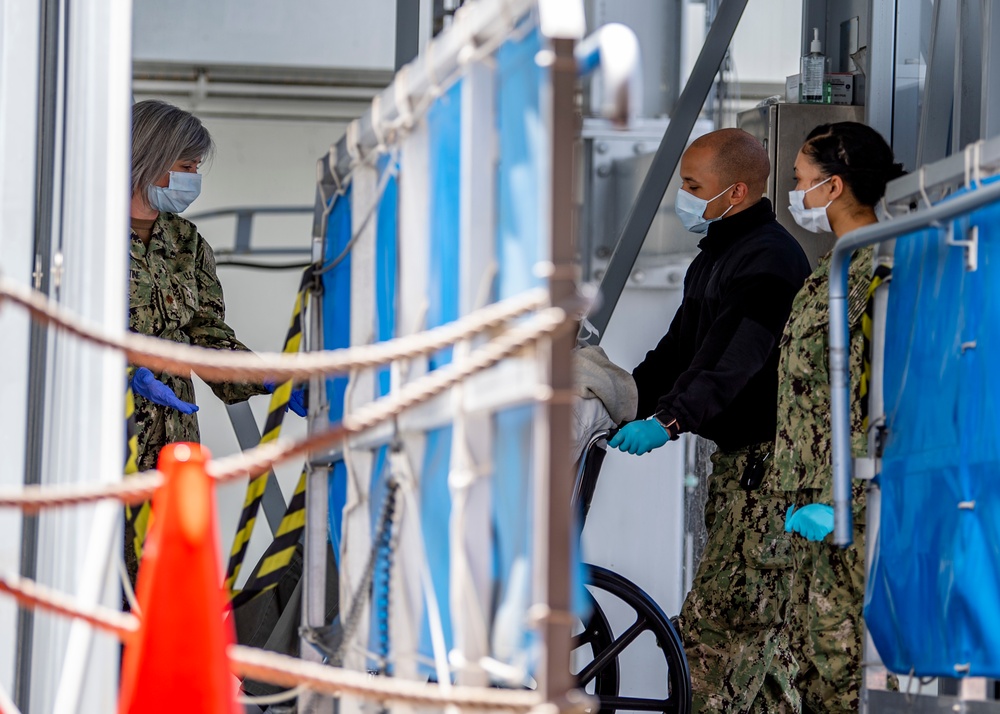 USNS Mercy Sailors Disembark a Patient