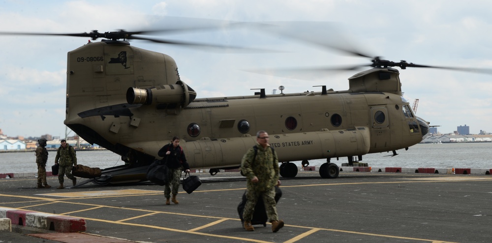 National Guard Soldiers and New York Naval Militia disembark from A CH-47 Chinook helicopter.