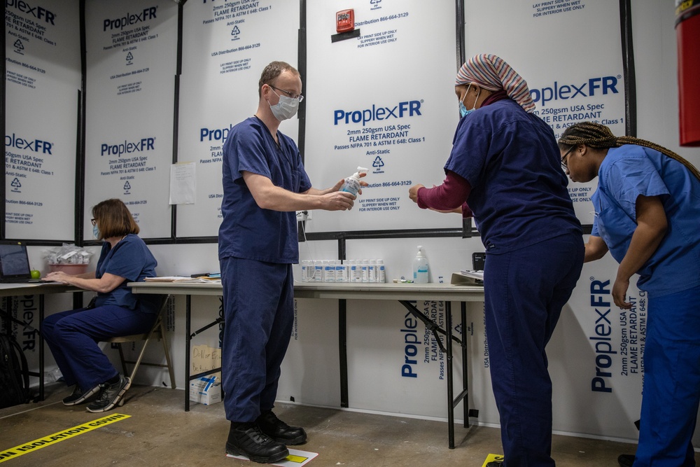 USPHS Personnel aid in the donning of PPE