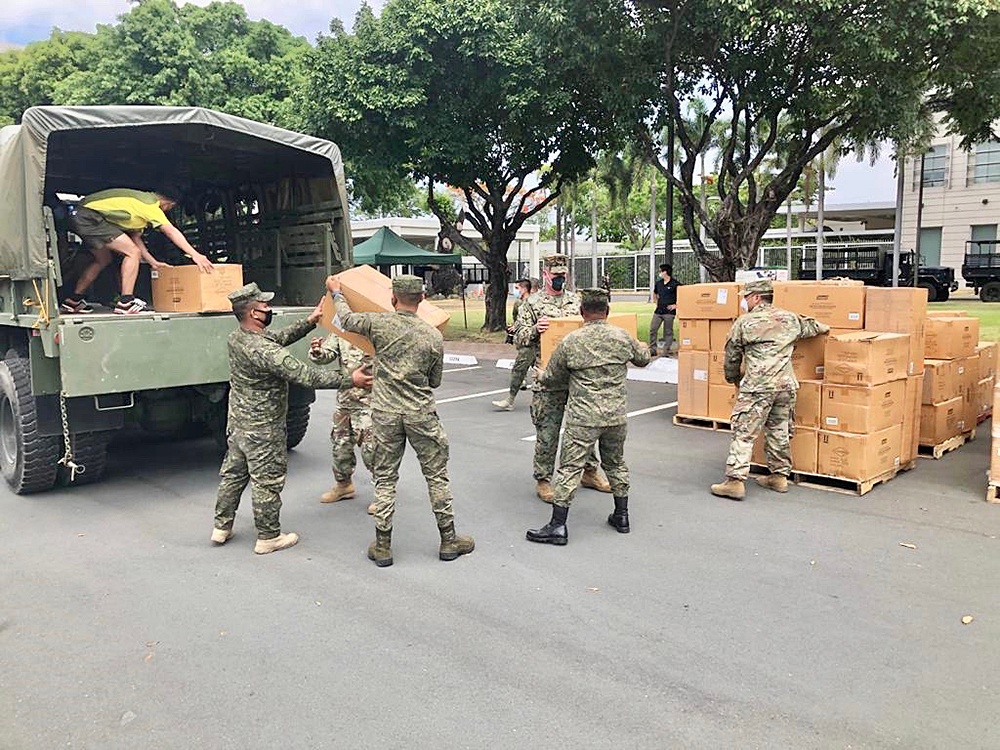 Service members load cot pad boxes for donation