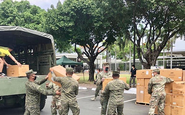 Service members load cot pad boxes for donation