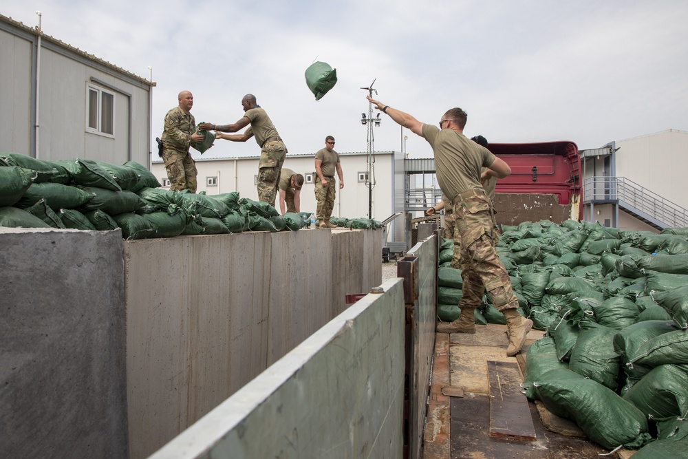 Soldiers unload and stack sandbags at Erbil Air Base