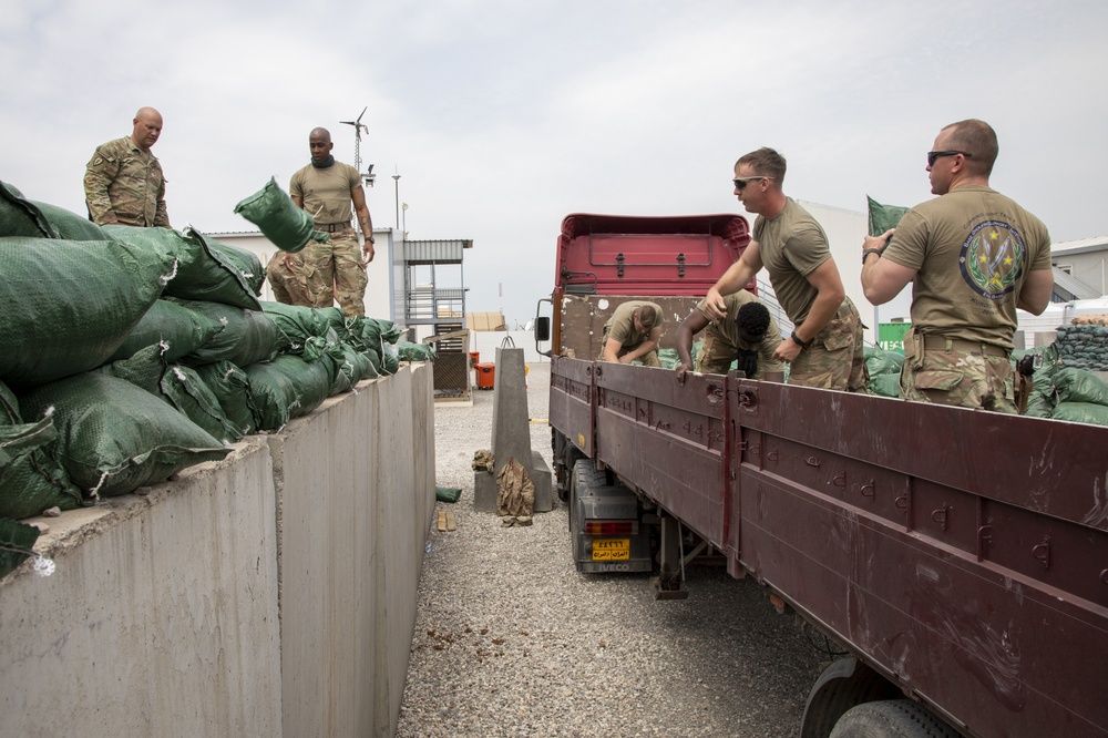 Soldiers unload and stack sandbags at Erbil Air Base