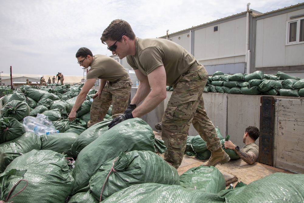 Soldiers unload and stack sandbags at Erbil Air Base