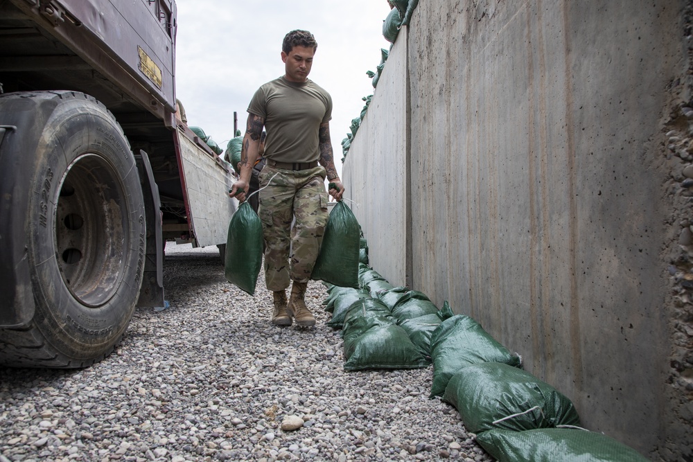 Soldiers unload and stack sandbags at Erbil Air Base