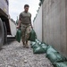 Soldiers unload and stack sandbags at Erbil Air Base