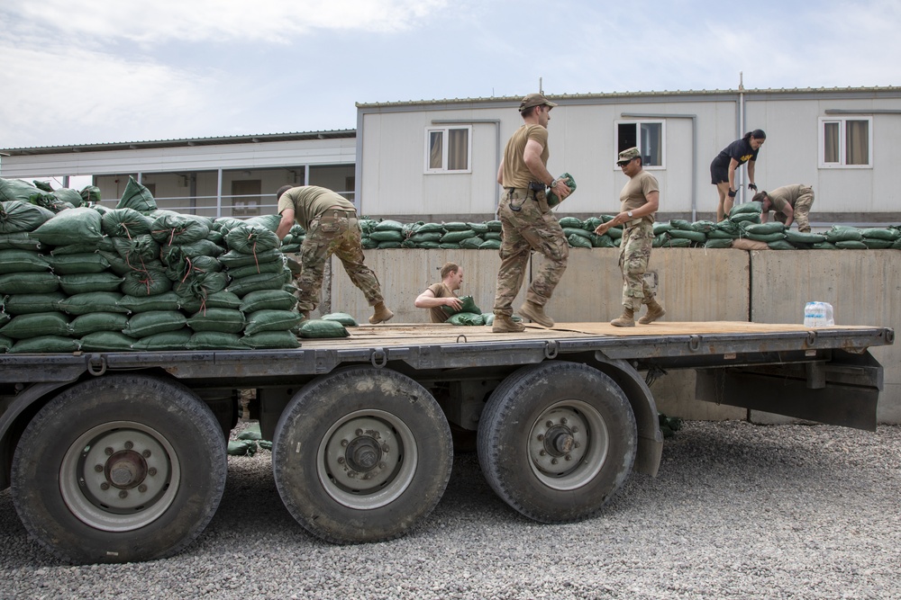 Soldiers unload and stack sandbags at Erbil Air Base