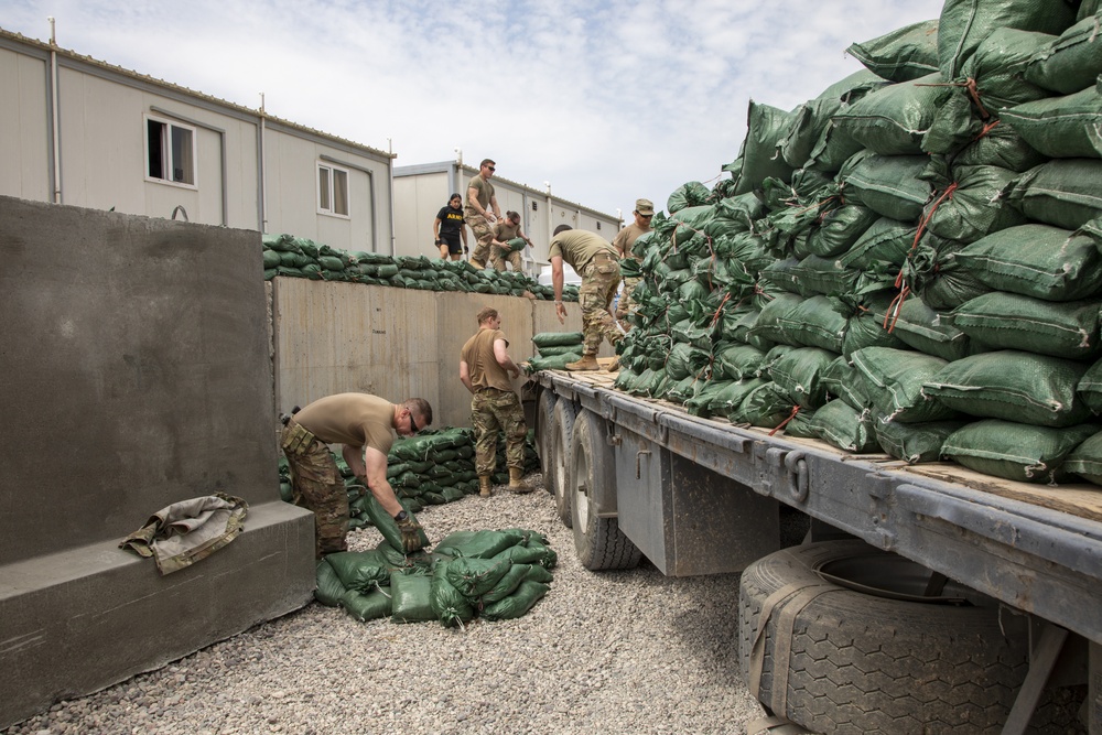 Soldiers unload and stack sandbags at Erbil Air Base