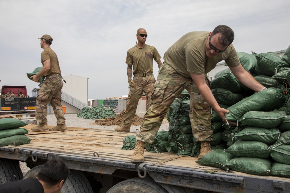 Soldiers unload and stack sandbags at Erbil Air Base