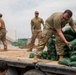 Soldiers unload and stack sandbags at Erbil Air Base