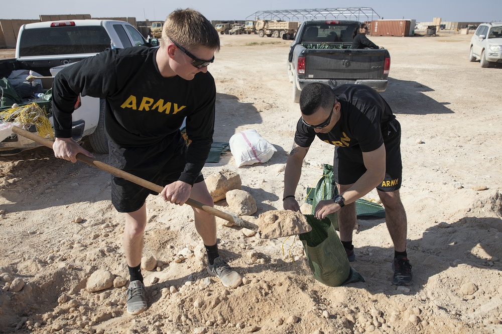 Soldiers fill sandbags and increase force protection measures