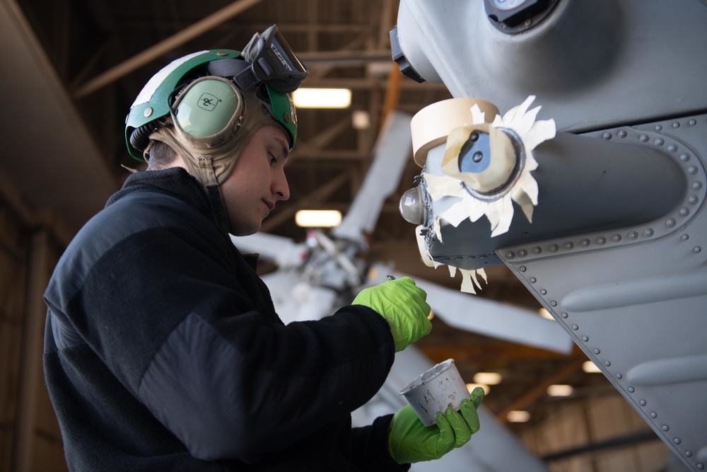 Sailor does maintenance on MH-60S Sea Hawk