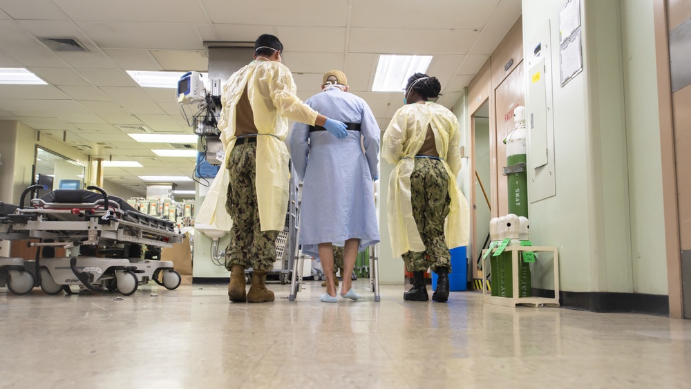 USNS Mercy Sailors Walk Alongside Patient