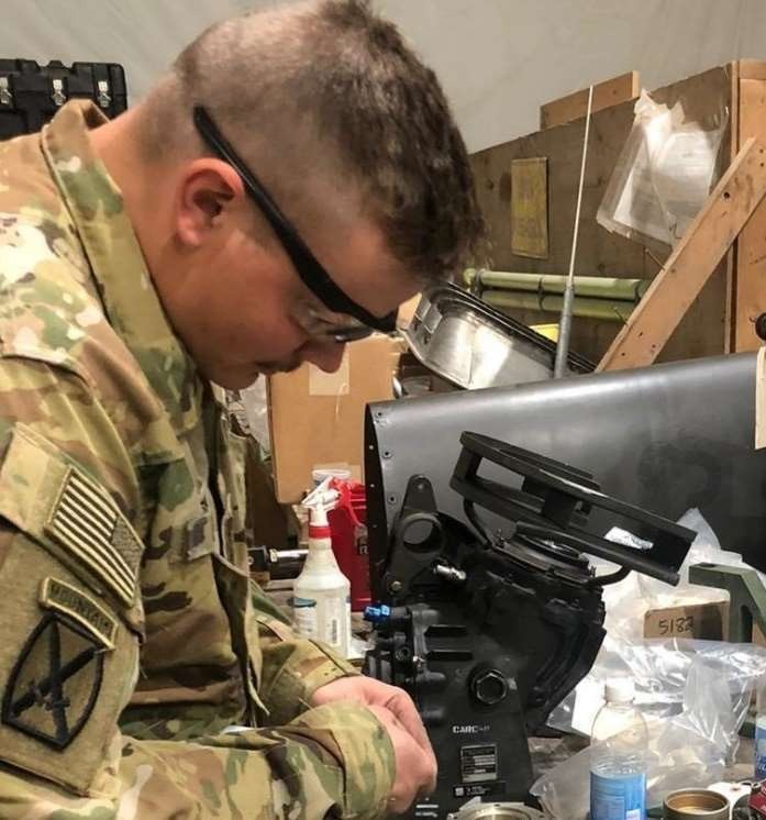 Sgt. Nathan Nolen is reassembling a tail rotor gearbox for an AH-64E Apache Helicopter.