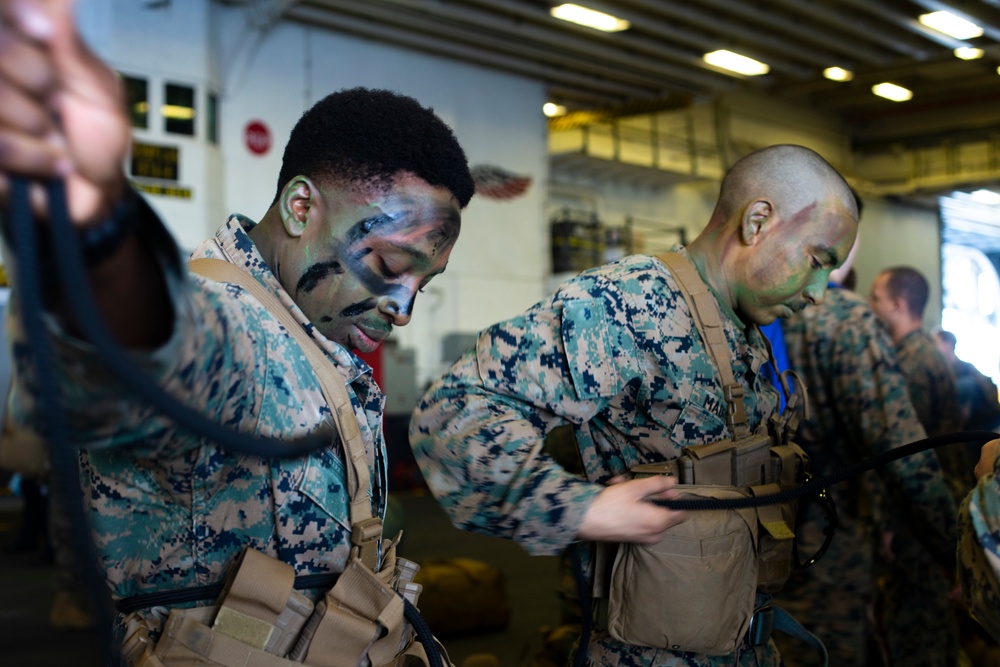 Marines conduct tactical cargo net debarkation from amphibious assault ship USS America (LHA 6).