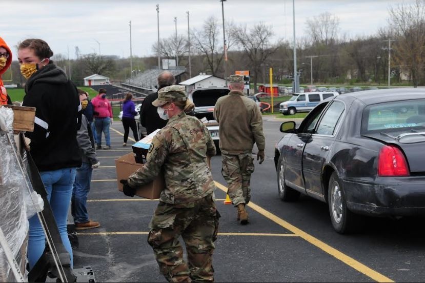 Soldier works with Community Voluteers to Load Trunks with Food