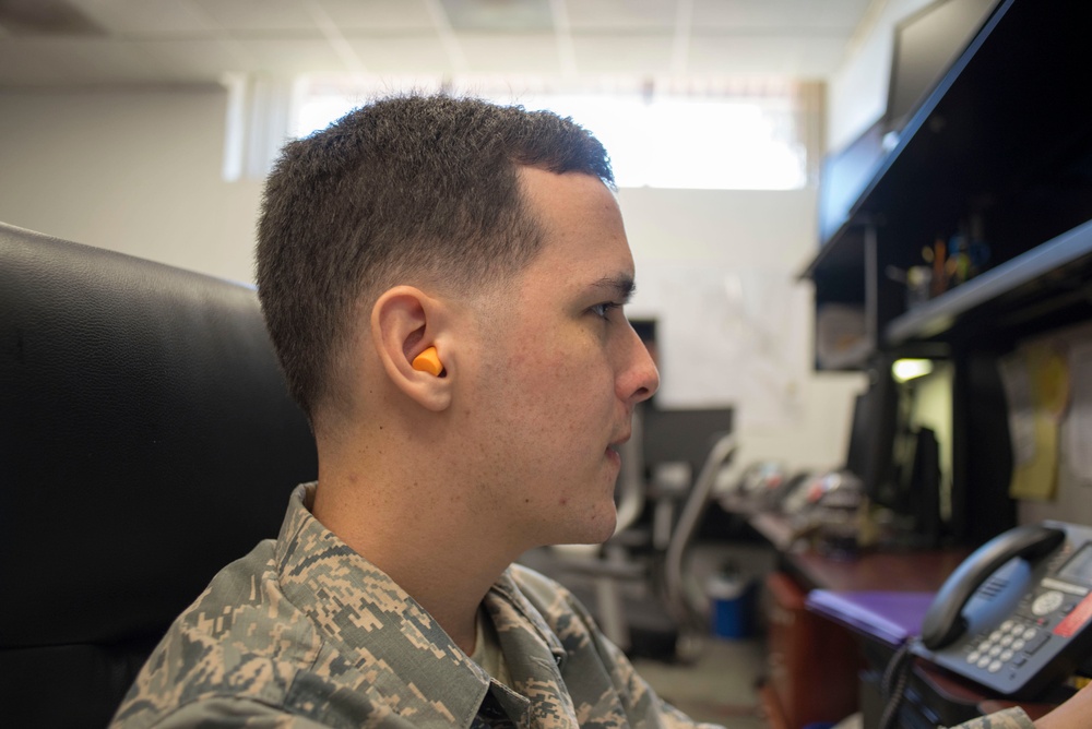 DVIDS Images Airman uses ear protection as aircraft fly overhead