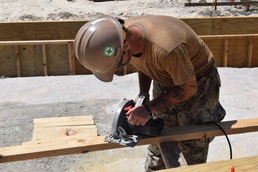 U.S. Navy Seabees from NMCB 5’s Detail Diego Garcia place concrete in support of the U.S. Air Force