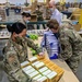 U.S. Rep. Rick Larsen helps Guardsmen build food boxes at Food Lifeline Warehouse