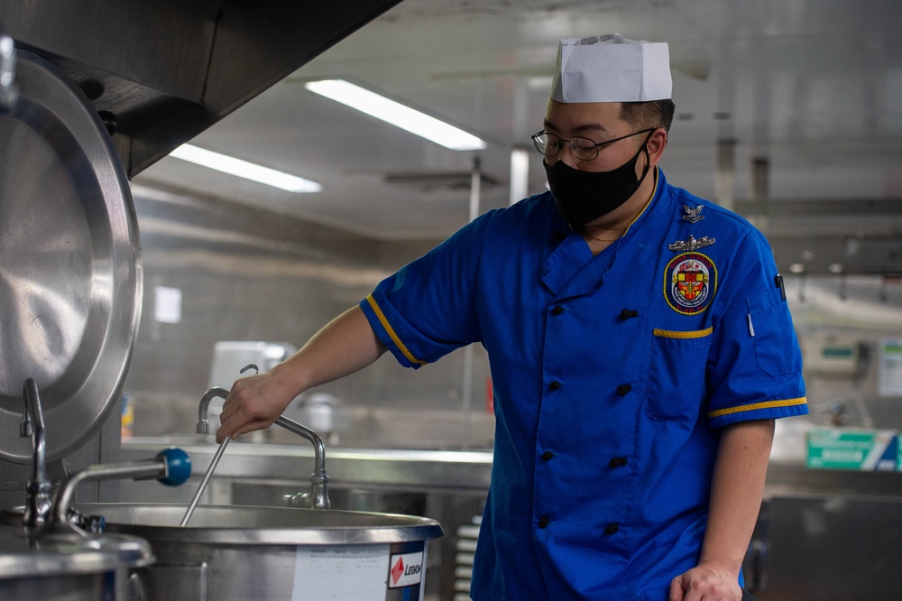 USNS Mercy Sailor Stirs Pasta