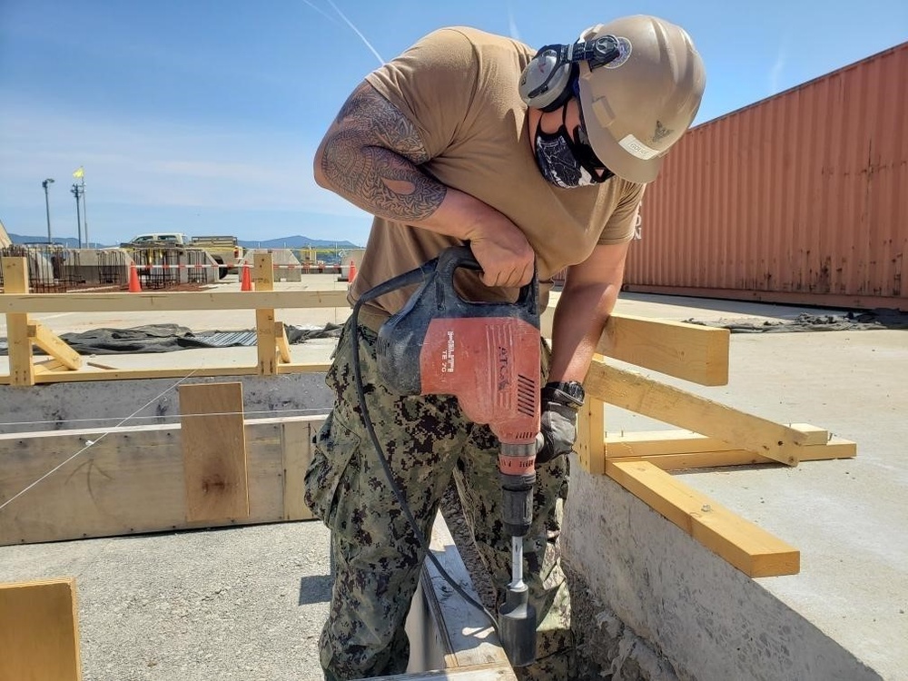 U.S. Navy Seabees deployed with NMCB-5’s Detail Sasebo are construct buildings for Naval Beach Unit 7