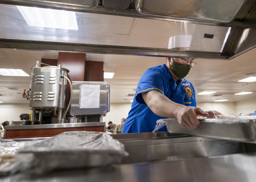 USNS Mercy Culinary Specialist Prepares Salad Bar