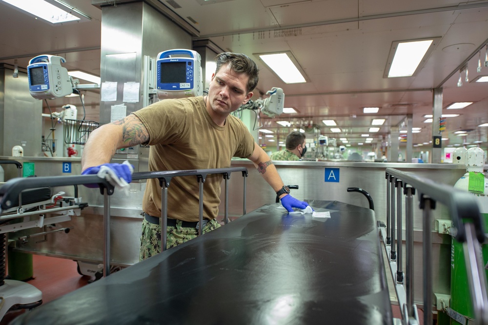 USNS Mercy Sailor Sanitizes Gurneys