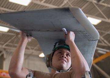 Sailor performs maintenance on MH-60S Sea Hawk