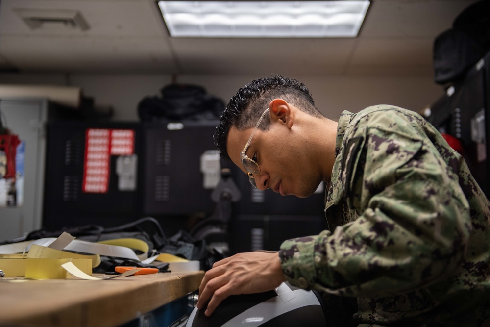 Sailor performs maintenance on aircrew helmet