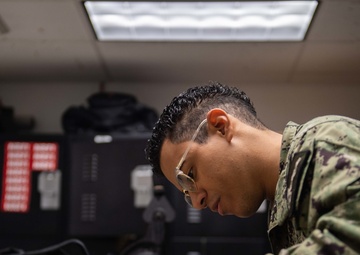 Sailor performs maintenance on aircrew helmet