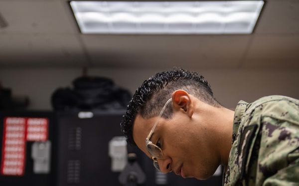 Sailor performs maintenance on aircrew helmet