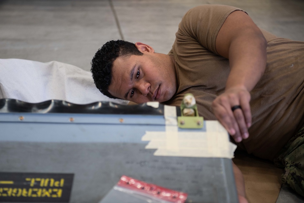 Sailor performs maintenance on MH-60S Sea Hawk