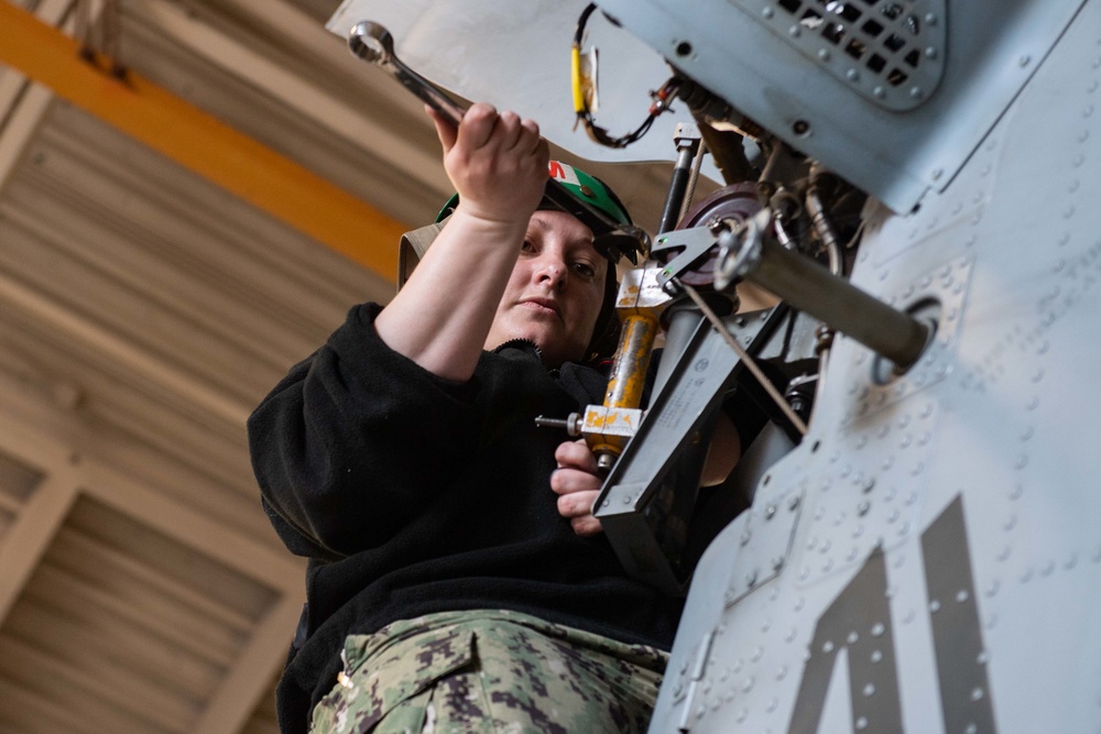 Sailor performs maintenance on MH-60S Sea Hawk