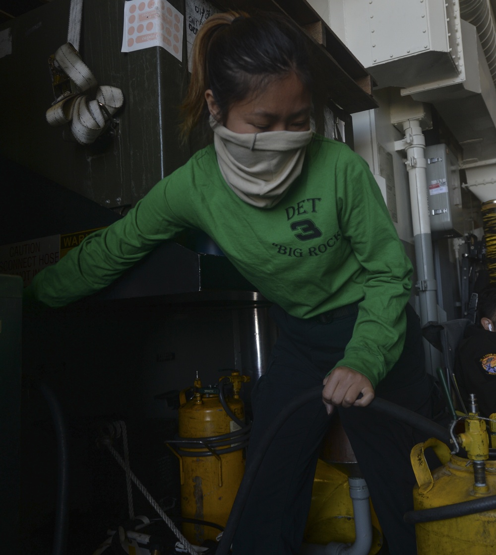 Sailor Fills Engine Water Wash Bottle