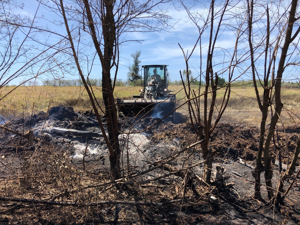 U.S. Navy Seabees with NMCB-5’s Detail Tinian help fight a local brushfire