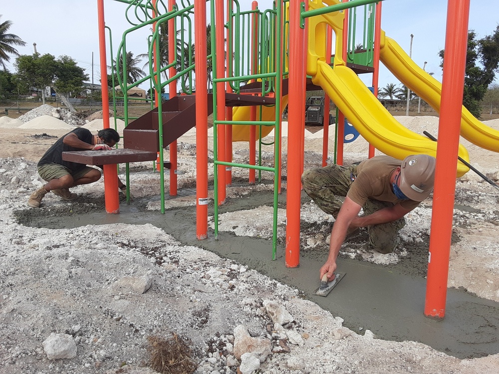 U.S. Navy Seabees with NMCB-5’s Detail Tinian install jungle gym at a children’s park
