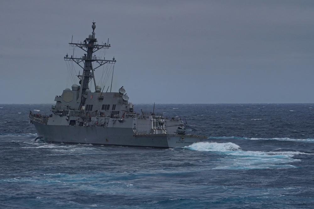 The Arleigh Burke-class guided-missile destroyer USS Ralph Johnson (DDG 114) transits the Pacific Ocean during a composite training unit exercise (COMPTUEX) as part of the Nimitz Carrier Strike Group (CSG).