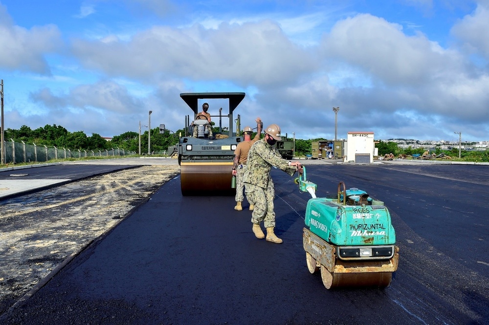 U.S. Navy Seabees with NMCB-5 place asphalt for Marine Air Control Squadron 4